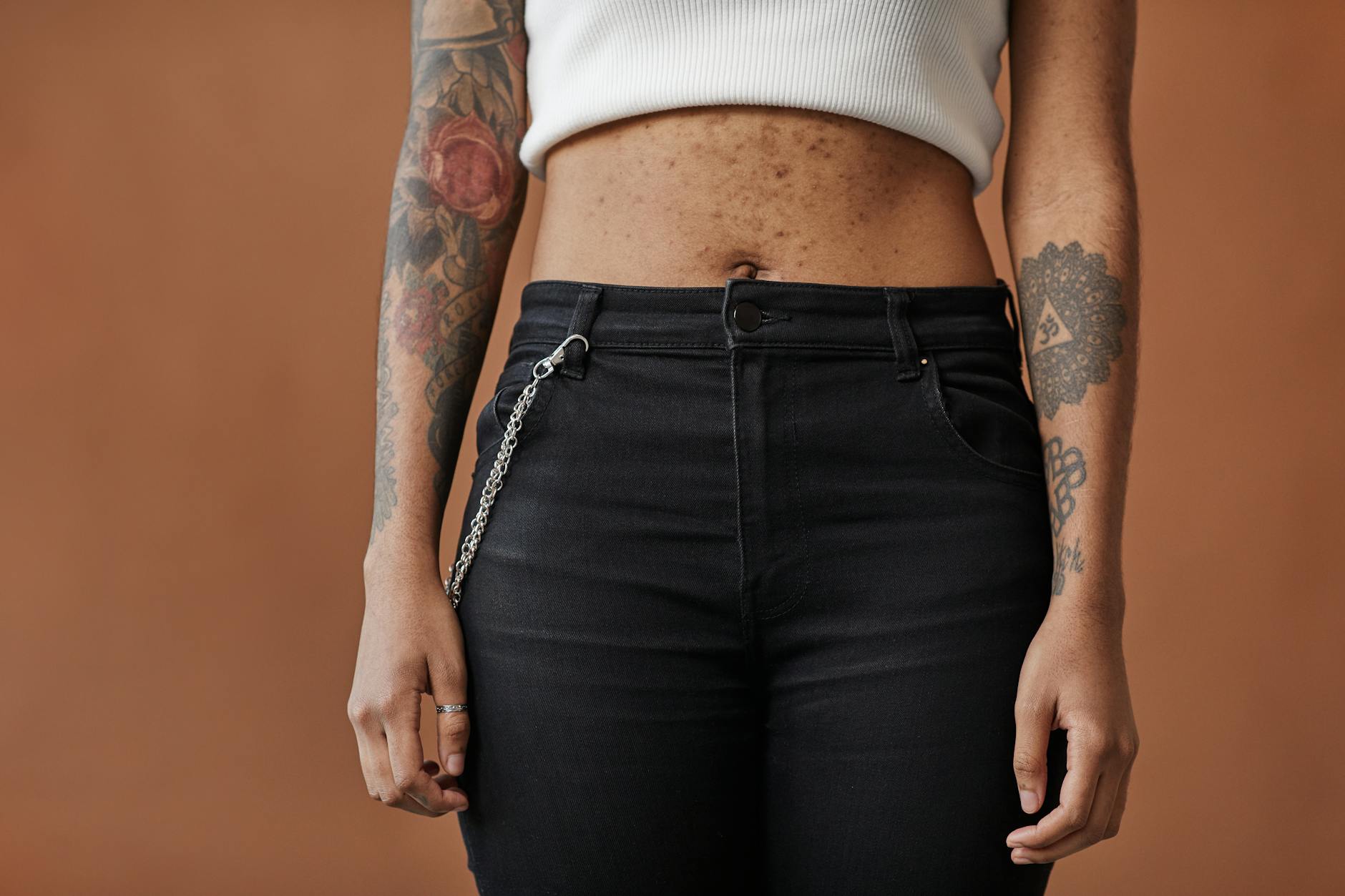 a tattooed person with acne on her belly