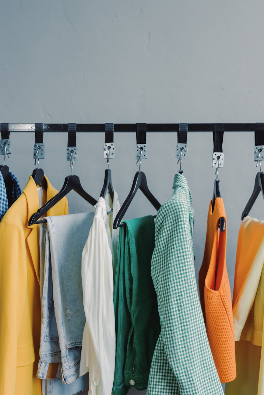 assorted clothes hanging on black steel rack